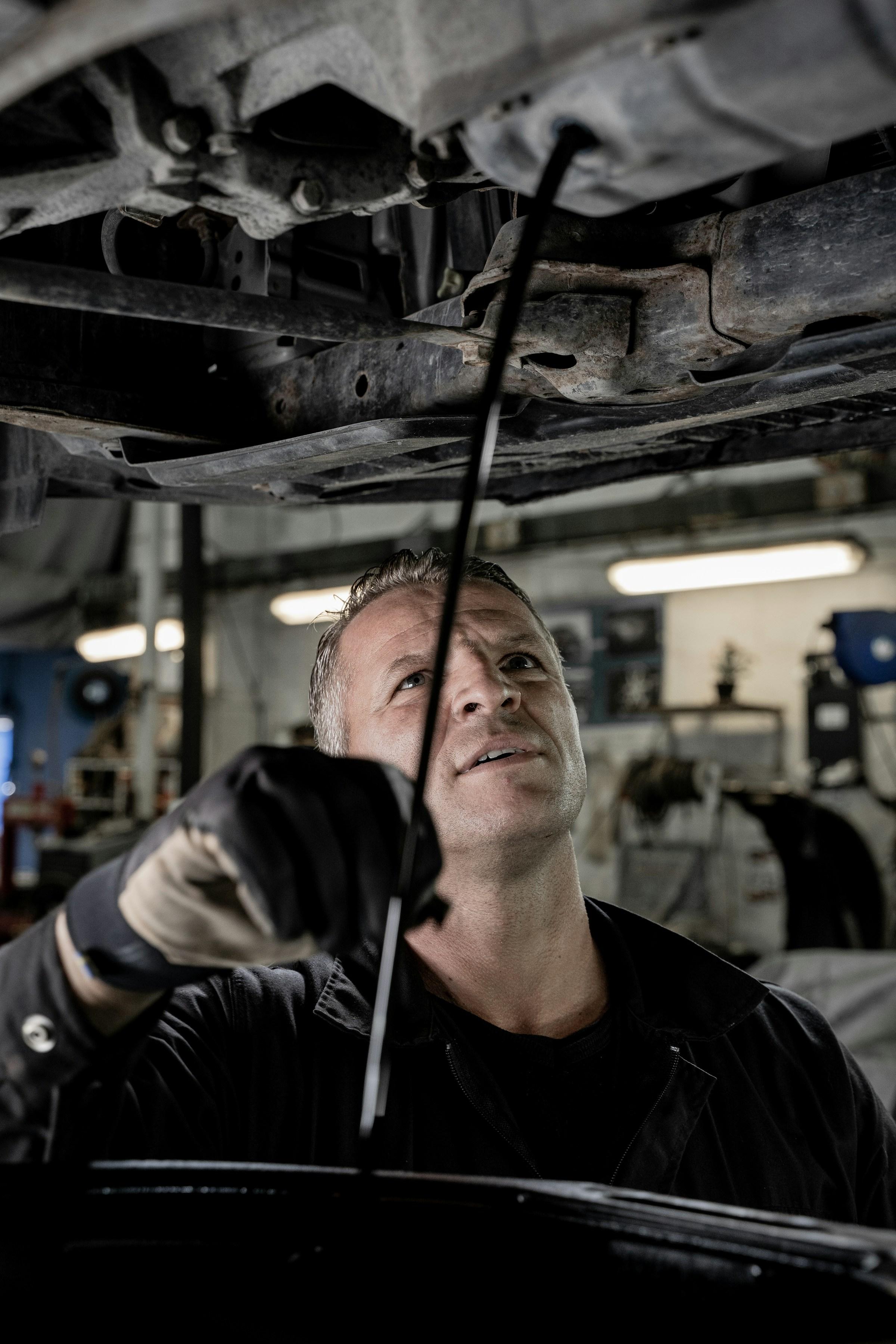 Mechanic working on a car under workshop lighting